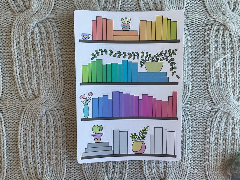 May include: A printable sticker sheet with three shelves of rainbow colored books, plants, and a cup of coffee. The shelves are white with a black outline.