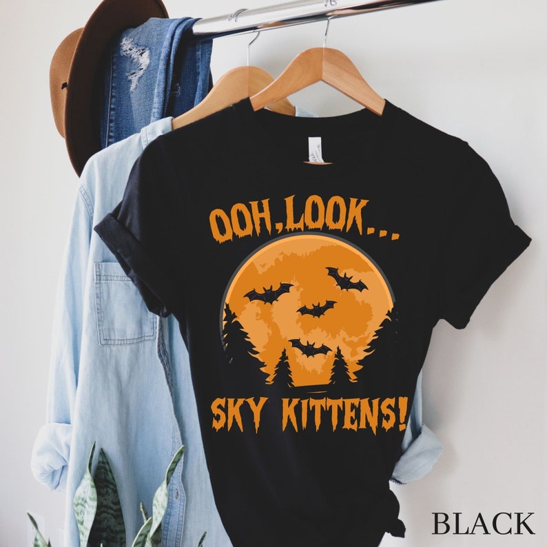 May include: Black t-shirt with a graphic of a full moon and bats with the text "Ooh, look... Sky Kittens!"