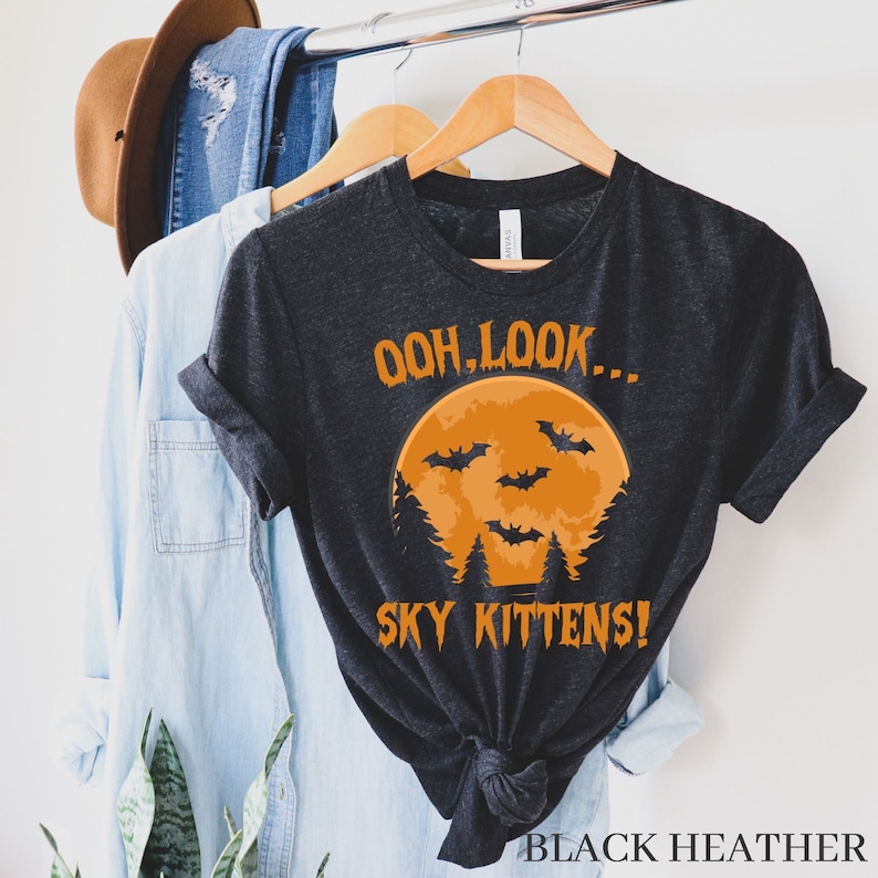 May include: Black heather grey t-shirt with an orange moon and bats graphic. The text "Ooh, look... Sky Kittens!" is printed on the shirt.