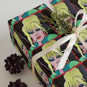 May include: Gift wrap featuring a repeating pattern of a cartoon woman with blonde hair, wearing a green shirt and red earrings, smoking a cigarette. The background is black with red and yellow accents.