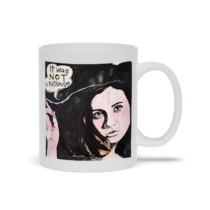 May include: White ceramic mug with a black and white illustration of a woman with long dark hair. The woman is smoking a cigarette and the text "it was NOT a nuthouse" is in a speech bubble above her head.