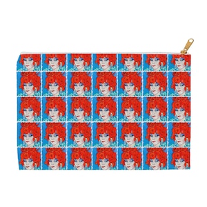 May include: A zippered pouch with a repeating pattern of a woman with red hair and blue eyes. The background is a light blue color.