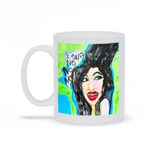 May include: White ceramic mug with a colorful illustration of a woman with black hair and red lips. The text "I said no no no" is written in black on a white background.