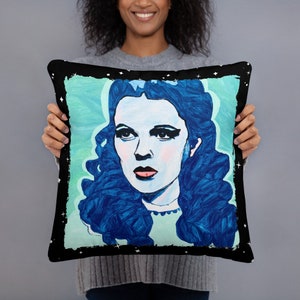 May include: A black and white throw pillow with a blue and green illustration of Dorothy from the Wizard of Oz. The illustration is painted in a stylized, abstract style.