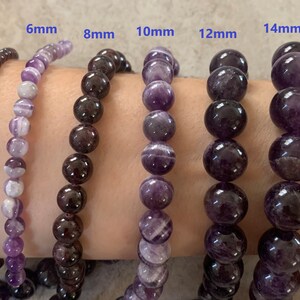 K&ouml;nnte beinhalten: Sechs Amethyst-Armb&auml;nder an einem Handgelenk, jedes mit einer anderen Perlengr&ouml;&szlig;e: 4 mm, 6 mm, 8 mm, 10 mm, 12 mm und 14 mm.