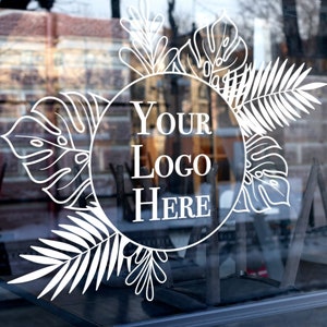 Könnte beinhalten: Ein weißes Schaufenster mit einem weißen floralen Design und dem Text "YOUR LOGO HERE" in einem Kreis.