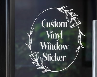 May include: White vinyl sticker with a floral wreath design. The sticker says "Custom Vinyl Window Sticker".