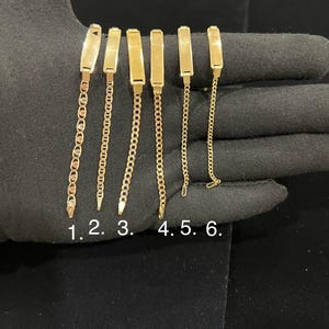 May include: Six gold-colored bracelets with different chain styles are displayed. Each bracelet features a rectangular plate connected to a chain. The chains vary in design, including link and rope styles. The bracelets are numbered 1 through 6.