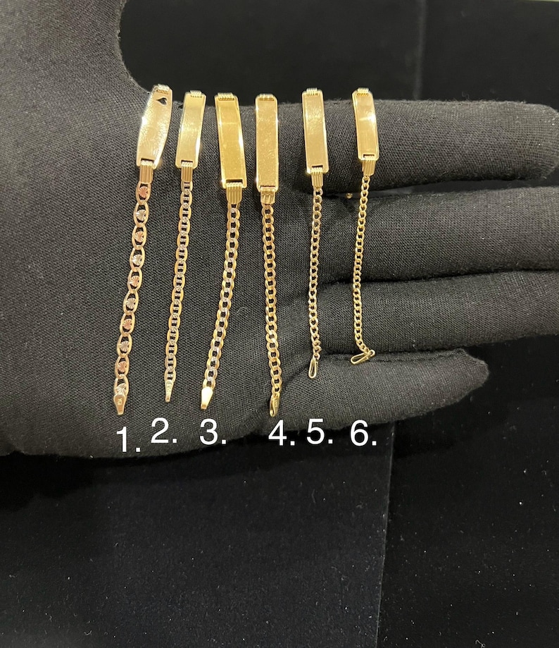 May include: Six gold-colored bracelets with different chain styles are displayed. Each bracelet features a rectangular plate connected to a chain. The chains vary in design, including link and rope styles. The bracelets are numbered 1 through 6.