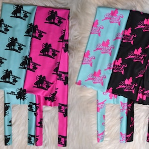 May include: Leggings in turquoise and hot pink, featuring a black silhouette of a horse and rider with text. Another pair of leggings in turquoise and black with a pink "Barrel Babe" logo.