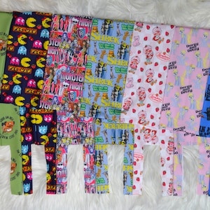 May include: Eight different fabric panels with various colorful cartoon and character designs. The designs include Cars, Pac-Man, Monster High, Shrek, Strawberry Shortcake, My Little Pony, and How to Train Your Dragon.