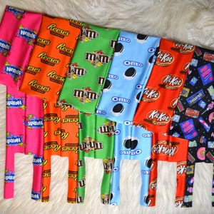 May include: A set of ten colorful fabric headbands with different candy bar logos printed on them. The headbands are made of a soft, stretchy fabric and are perfect for adding a pop of color to any outfit.