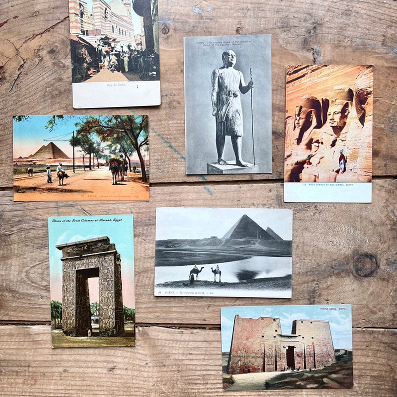May include: A collection of vintage postcards depicting scenes from Egypt. The postcards feature images of the Temple of Karnak, the Sphinx, and the Great Pyramids. The postcards are in black and white and have a vintage aesthetic.