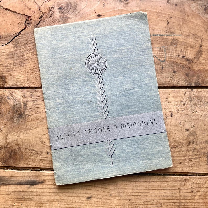 Puede incluir: Un libro vintage con una cubierta azul claro, con el texto "ROCK AGES" en un emblema circular y "HOW TO CHOOSE A MEMORIAL". La cubierta tiene una apariencia texturizada y un elemento de dise&ntilde;o vertical.
