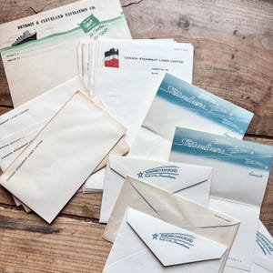 May include: A selection of vintage travel documents, including envelopes and brochures. The items feature logos and text for Detroit & Cleveland Navigation Co., Canada Steamship Lines, and Seaboard Railroad. The color scheme includes cream, blue, and red.
