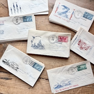Könnte beinhalten: Eine Sammlung alter weißer Umschläge mit verschiedenen Illustrationen in blauer und roter Tinte, darunter Kriegsschiffe, Adler und amerikanische Flaggen. Jeder Umschlag zeigt Poststempel, Briefmarken und handschriftliche Adressen in Schreibschrift.