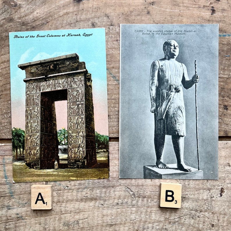 May include: Two vintage postcards. The first postcard shows the ruins of the Great Columns at Karnak, Egypt. The second postcard shows a wooden statue of the Sheikh-el Beled, in the Egyptian Museum.