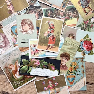 May include: A collection of vintage ephemera, including trade cards and advertising cards. The cards feature illustrations of people, flowers, and advertisements. Some cards have text, including "Best Family Paper" and "Ladies Fine Shoes".