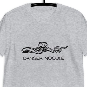 May include: A heather grey t-shirt with a black graphic of a snake with the text "DANGER NOODLE" underneath.