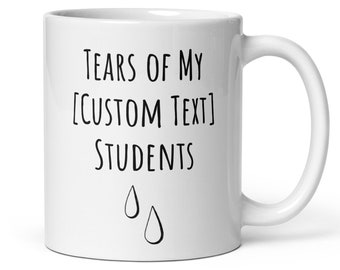 May include: White ceramic coffee mug with black text that reads "Tears of my [CUSTOM TEXT] Students" with two black teardrop illustrations below the text.