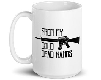 May include: White ceramic coffee mug with a black silhouette of a rifle and the text "From my cold dead hands".