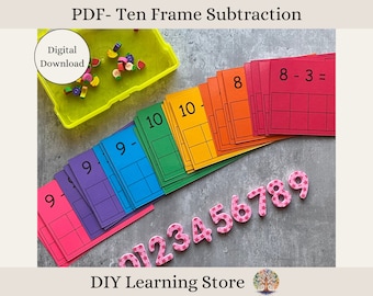 May include: A set of ten frame subtraction cards with a rainbow of colors. The cards are numbered 1-10 and have a subtraction equation on each card. The cards are arranged in a rainbow pattern, with the red card at the top and the green card at the bottom. There are also pink foam numbers 0-9 and a container of colorful fruit-shaped erasers.
