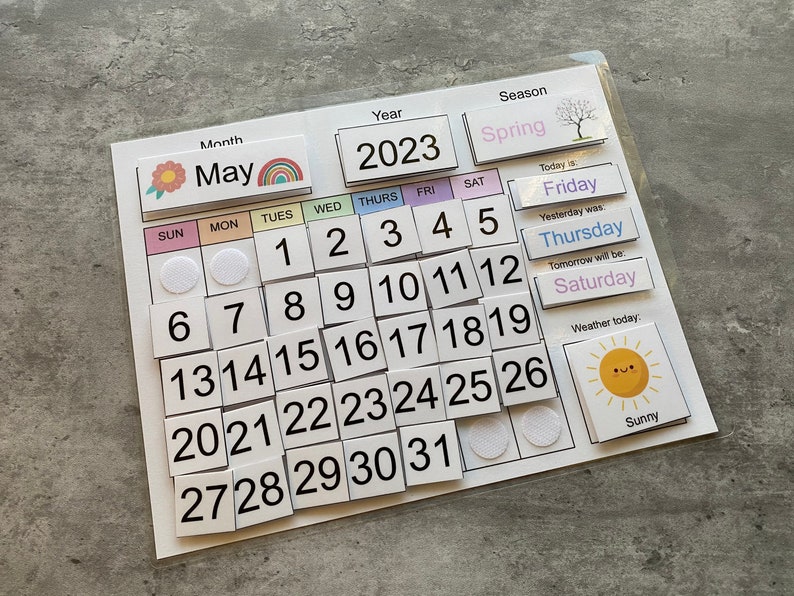 Pu&ograve; includere: Un calendario colorato di maggio 2023 con un arcobaleno, un fiore e un sole. Il calendario ha i giorni della settimana, i numeri da 1 a 31 e una sezione per la stagione, la data di oggi, la data di ieri, la data di domani e il tempo.