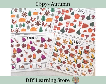 May include: Four printable "I Spy" game cards featuring autumn-themed illustrations. Each card has a different set of images, including pumpkins, leaves, acorns, and other fall elements. The cards are designed for children to practice counting and visual recognition skills.
