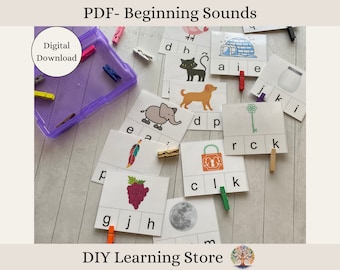 May include: A set of printable beginning sounds flashcards featuring various images, such as an elephant, a feather, a grape, a moon, a lock, a key, a dog, a cat, an igloo, and a jar. The cards are designed for use with clothespins to help children learn beginning sounds.