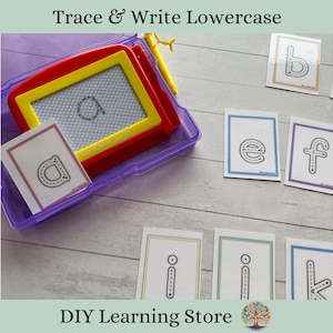May include: A set of lowercase letter tracing cards with a purple and yellow magnetic drawing board. The cards are on a light wood surface. The cards have a black and white outline of the lowercase letters a, b, e, f, i, k. The magnetic drawing board has a clear plastic cover and a yellow frame. The board has a black and white outline of the lowercase letter a.