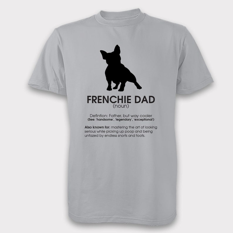 K&ouml;nnte beinhalten: Ein graues T-Shirt mit einer schwarzen Silhouette eines franz&ouml;sischen Bulldoggen und dem Text "FRENCHIE DAD (Substantiv)". Der Text unter der Silhouette definiert einen Frenchie Dad als einen Vater, der cool, gutaussehend, legend&auml;r und au&szlig;ergew&ouml;hnlich ist. Der Text erw&auml;hnt auch, dass ein Frenchie Dad daf&uuml;r bekannt ist, die Kunst zu beherrschen, ernst zu wirken, w&auml;hrend er Kot aufsammelt und von endlosen Schn&uuml;ffeln und Furzen unbeeindruckt bleibt.