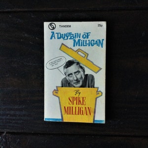 Puede incluir: Una portada de libro azul y amarilla con el título "A Dustbin of Milligan" de Spike Milligan. La portada presenta una imagen de dibujos animados de Spike Milligan dentro de un cubo de basura amarillo.