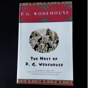 May include: A book titled The Most of P. G. Wodehouse with a white cover, a red top and bottom border featuring geometric patterns, and a central circular illustration of people in formal attire. The author's name is printed in white at the top.