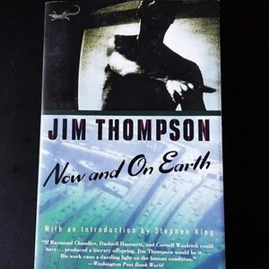 May include: A book cover with a black and white image of a person holding a knife. The title of the book is "JIM THOMPSON Now and On Earth" with an introduction by Stephen King. The quote "If Raymond Chandler, Dashiell Hammett, and Cornell Woolrich could have... produced a literary offspring, Jim Thompson would be it.... His work casts a dazzling light on the human condition." -Washington Post Book World is printed on the bottom of the cover.