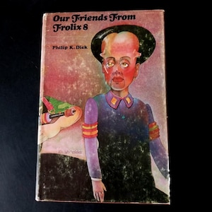 Może przedstawiać: Okładka książki w miękkiej oprawie w stylu vintage zatytułowana "Our Friends From Frolix 8" autorstwa Philipa K. Dicka. Grafika na okładce przedstawia humanoidalnego kosmitę z dużą głową, ubranego w fioletowy mundur. Przedstawiono również zielone stworzenie z bronią.