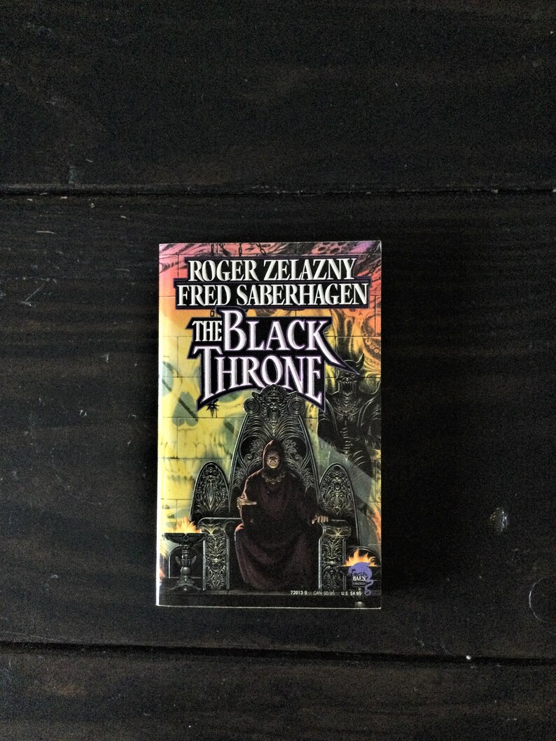 May include: A paperback book cover with a black and white illustration of a person sitting on a throne. The title of the book is "The Black Throne" and the authors are Roger Zelazny and Fred Saberhagen.