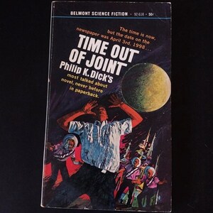 Peut inclure: Couverture de livre de poche vintage pour "Time Out of Joint" de Philip K. Dick. L'illustration montre un homme les bras levés, une planète jaune et des personnages en combinaisons spatiales. Le livre est de Belmont Science Fiction.