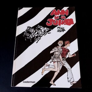 May include: A comic book cover with the title "ANN DE LA JUNGLE" in red and white lettering. The cover features a black and white striped background, a drawing of zebras, and two people running. The publisher's name, casterman, is at the bottom.