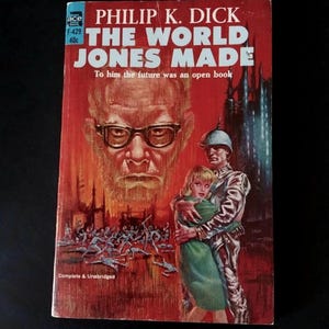 Peut inclure: Un livre de poche vintage de Philip K. Dick, intitulé "THE WORLD JONES MADE". La couverture présente une illustration d'un homme avec des lunettes, un soldat tenant une femme et un fond enflammé. Le livre est complet et non abrégé.
