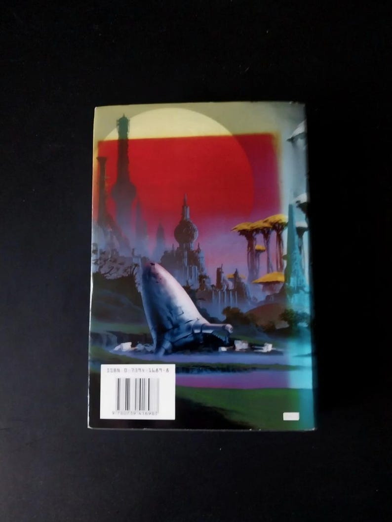 Puede incluir: Contraportada de un libro de bolsillo con una ilustraci&oacute;n de ciencia ficci&oacute;n. La obra de arte representa una ciudad futurista bajo un cielo rojo, con una gran estructura blanca en forma de nave espacial. Una etiqueta blanca con c&oacute;digo de barras es visible.