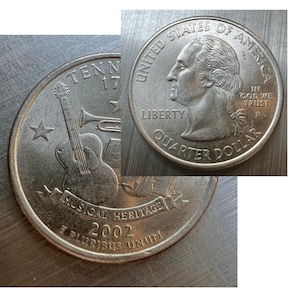 May include: A silver US quarter dollar coin featuring a musical heritage design. The coin depicts a guitar, trumpet, and musical notes with the text "Tennessee Musical Heritage 2002". The obverse side of the coin features a profile of George Washington with the text "United States of America, Liberty, In God We Trust, Quarter Dollar".