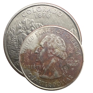 May include: Two United States quarters. One quarter features the Colorado landscape and the text "Colorado 1876". The other quarter displays George Washington's profile and the text "Quarter Dollar".