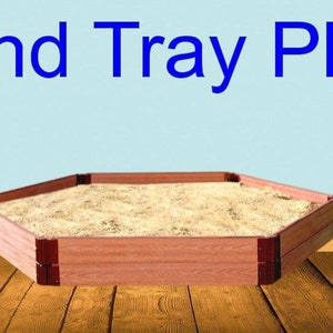 Peut inclure: Un bac à sable hexagonal en bois rempli de sable. Un ours en peluche brun est assis sur le sol en bois à côté du bac à sable. Le texte "Sand Tray Play" est écrit en lettres bleues en haut de l'image.