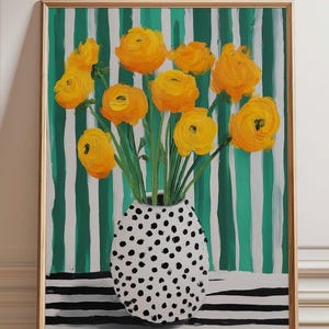 May include: A framed painting depicting yellow flowers in a white vase adorned with black polka dots. The background showcases green and white vertical stripes, with a black and white striped base. The artwork is a vibrant still life.