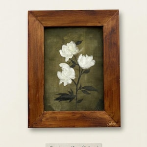 May include: A framed painting of white peonies on a moss-green background. The artwork is in a wooden frame. The painting is labeled "Peonies on Moss (2.75x3.15 in)" below the frame. The word "Shop" is written on the frame.