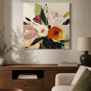 Könnte beinhalten: Abstrakte Blumenmalerei mit cremefarbenem Hintergrund. Das Kunstwerk zeigt große, ausdrucksstarke Pinselstriche in Orange-, Weiß-, Rosa- und Grüntönen. Das Gemälde wird über einem Holzschrank in einem Wohnzimmer ausgestellt.