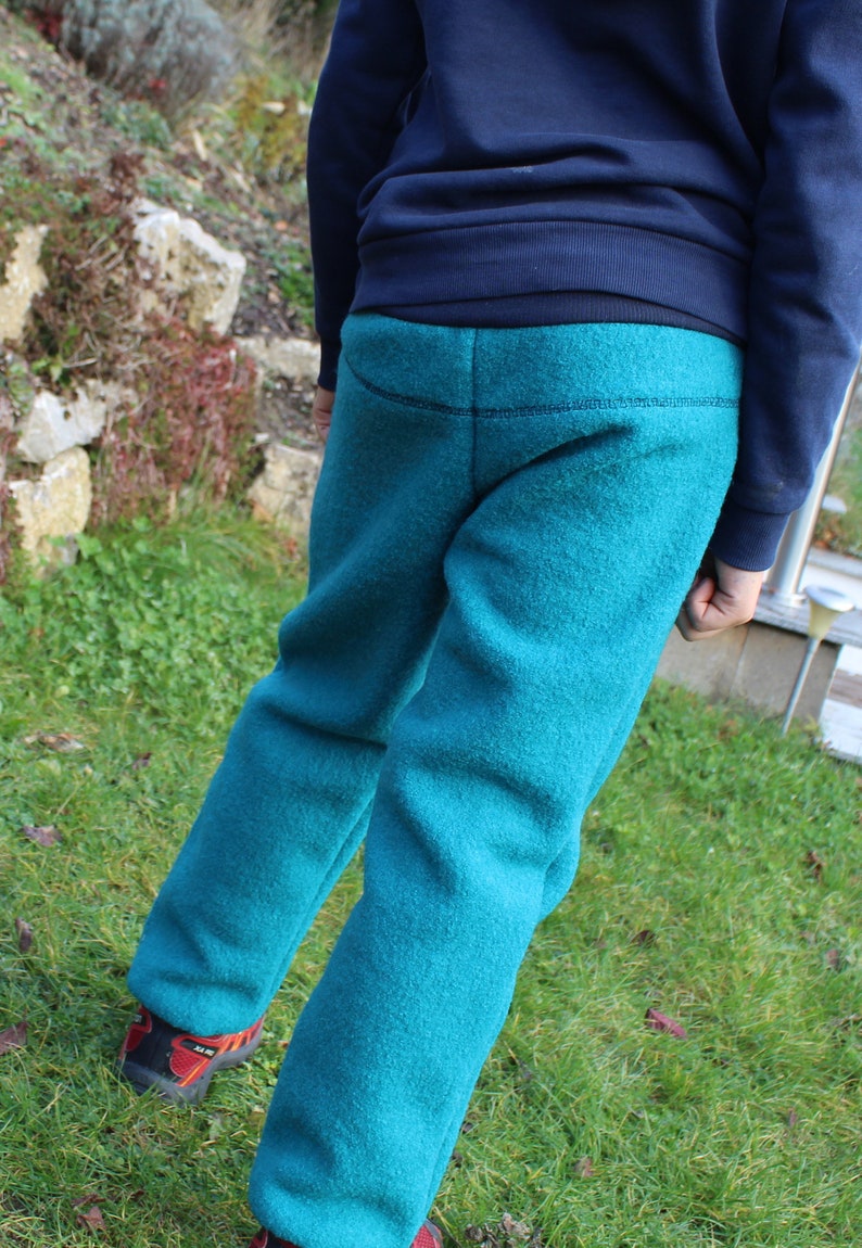 May include: A pair of teal blue fleece sweatpants with a dark blue waistband.