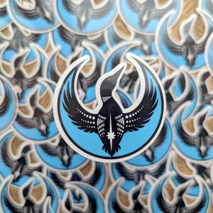 May include: A sticker featuring a stylized black bird with a white outline, set against a light blue circle. The bird has a red eye and a star on its chest. The background is filled with similar stickers.