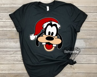 May include: Black t-shirt with a cartoon image of Goofy wearing a Santa hat. The image is in red, black, white, and brown.