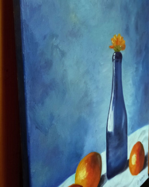 Blue Glass Wine Bottle With Oranges and Orange Flower in Oil